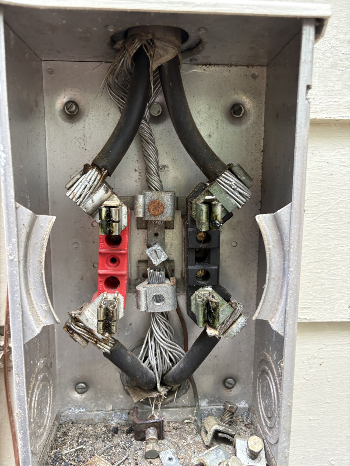 Inside of an old meter base showing heat-damaged jaws and connections