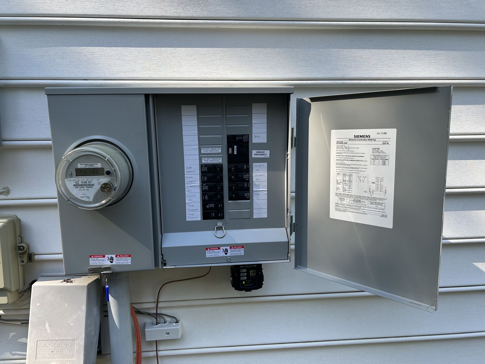 New outdoor meter combo with new breakers and a whole-house surge protector installed below it
