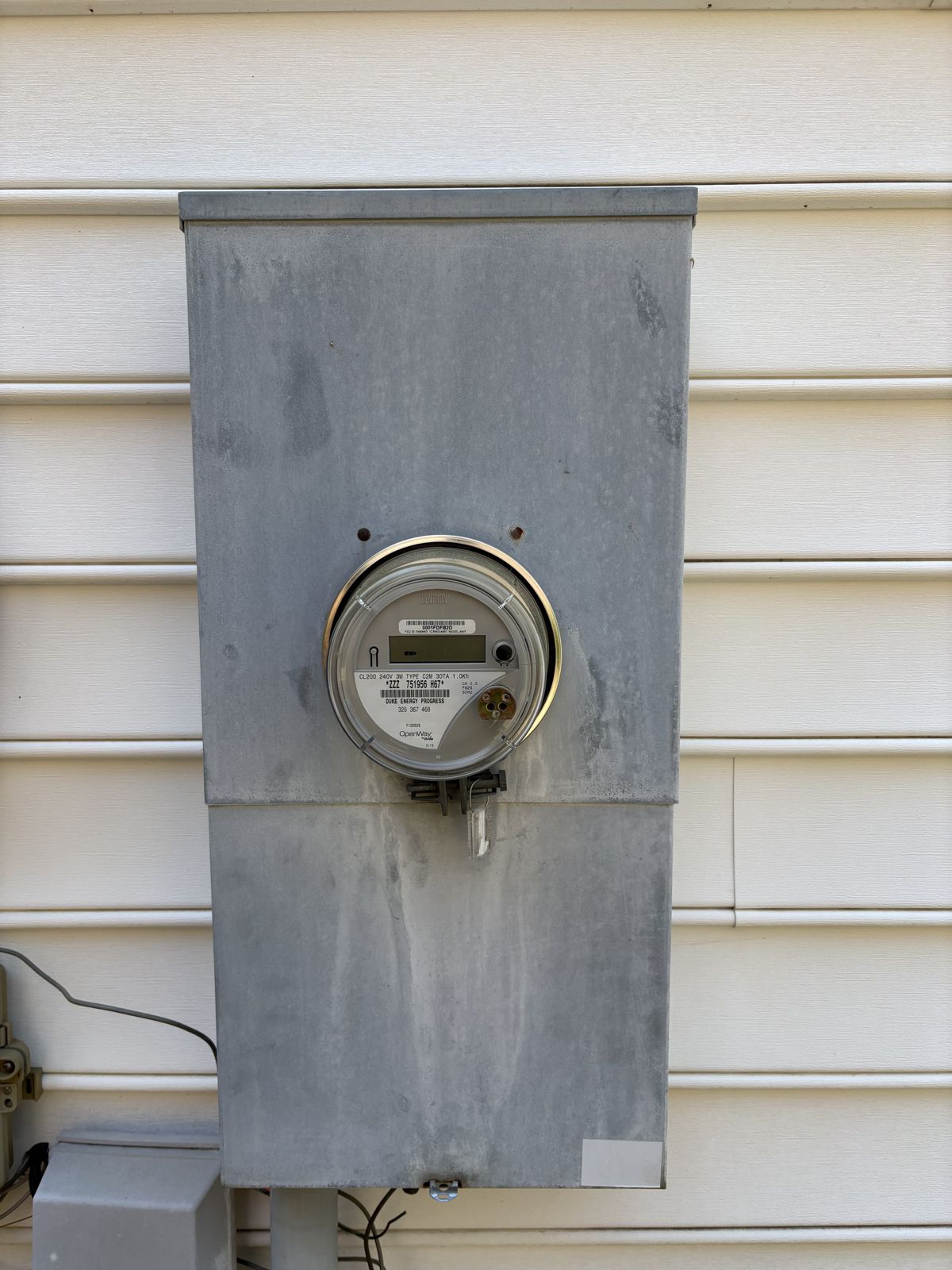 Corroded outdoor 200-amp meter combo on the side of a 1995 home in Cary, NC, before replacement