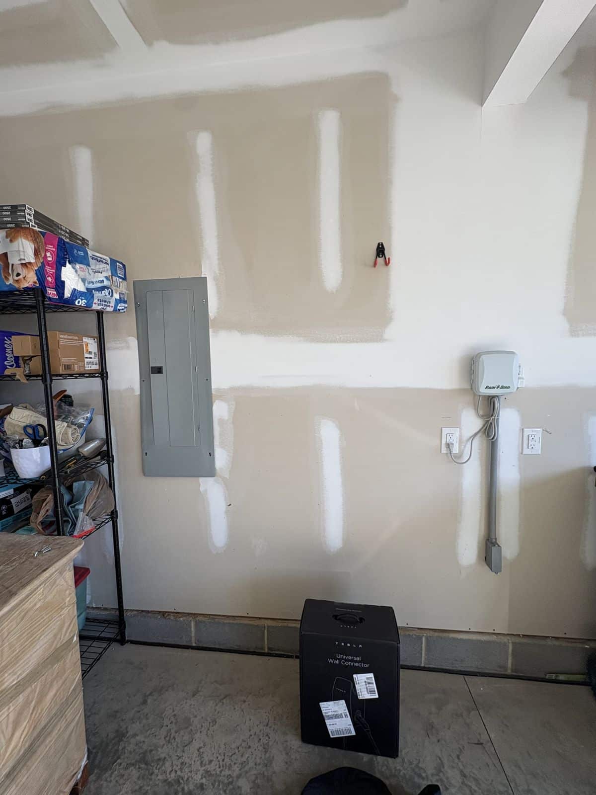 Garage wall next to the electrical panel before a Tesla Wall Connector installation in Fuquay-Varina, NC