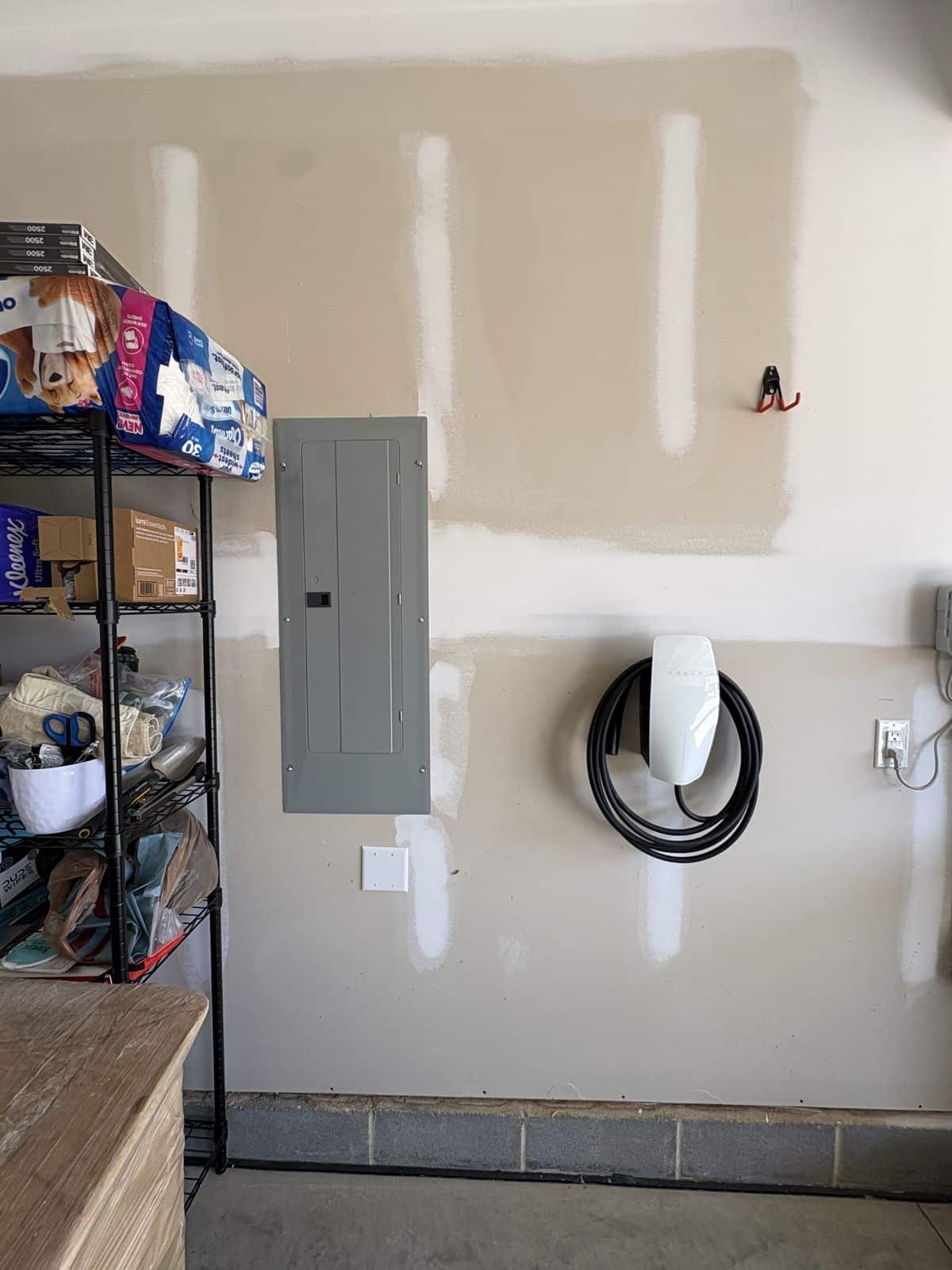 Tesla Wall Connector hardwired and mounted beside the electrical panel in a Fuquay-Varina garage