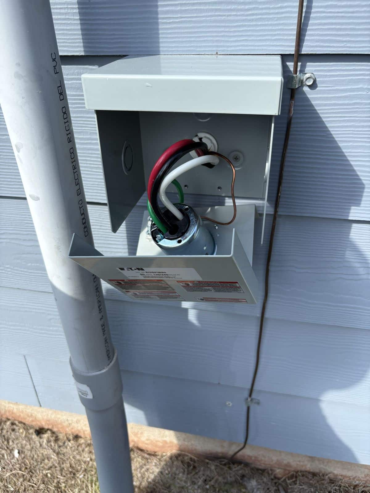 50-amp generator inlet box being wired on the outside wall of a home