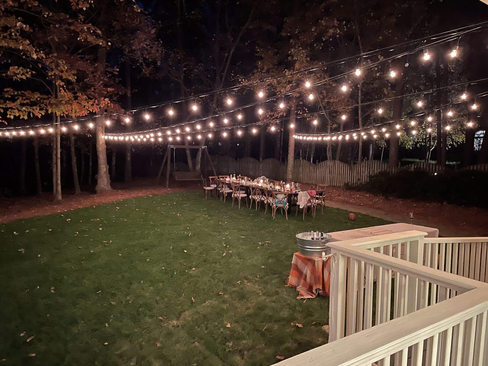Bistro string lights over a backyard dinner table