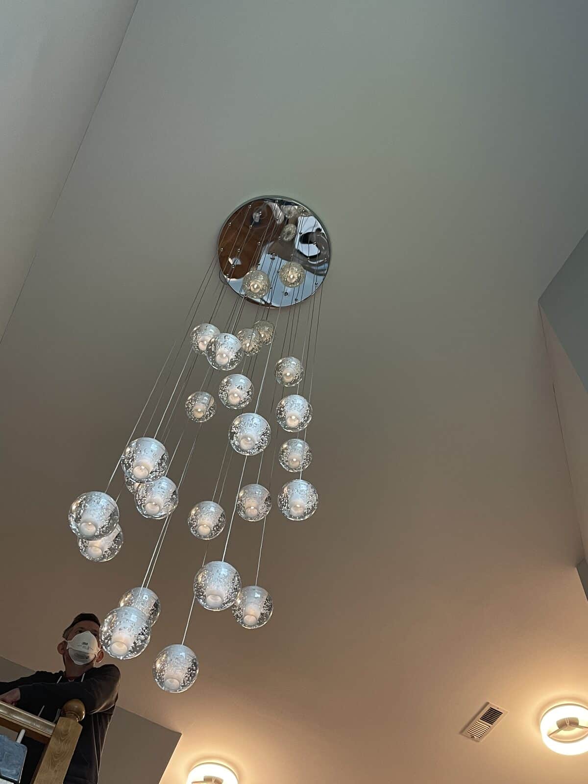Cascading bubble-glass pendant cluster in a stairwell