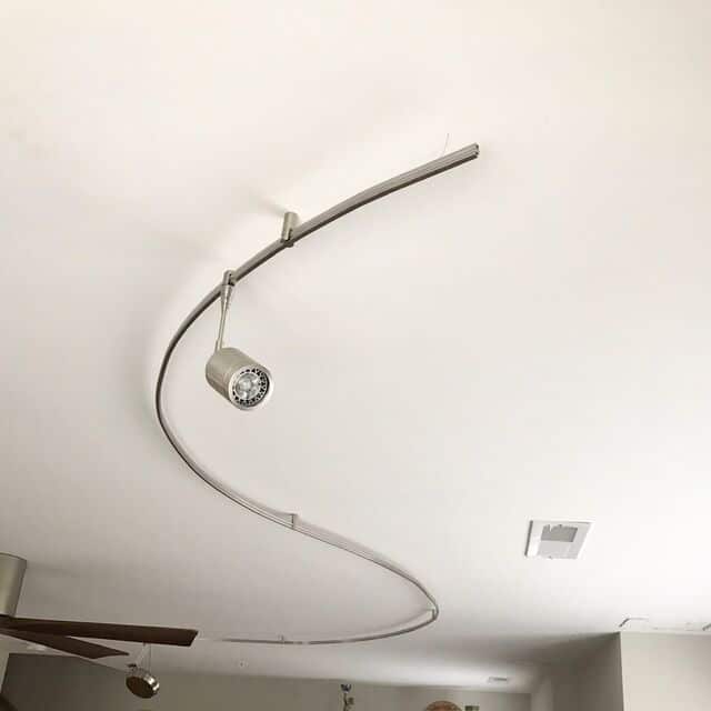 Curved track lighting installed on a living room ceiling
