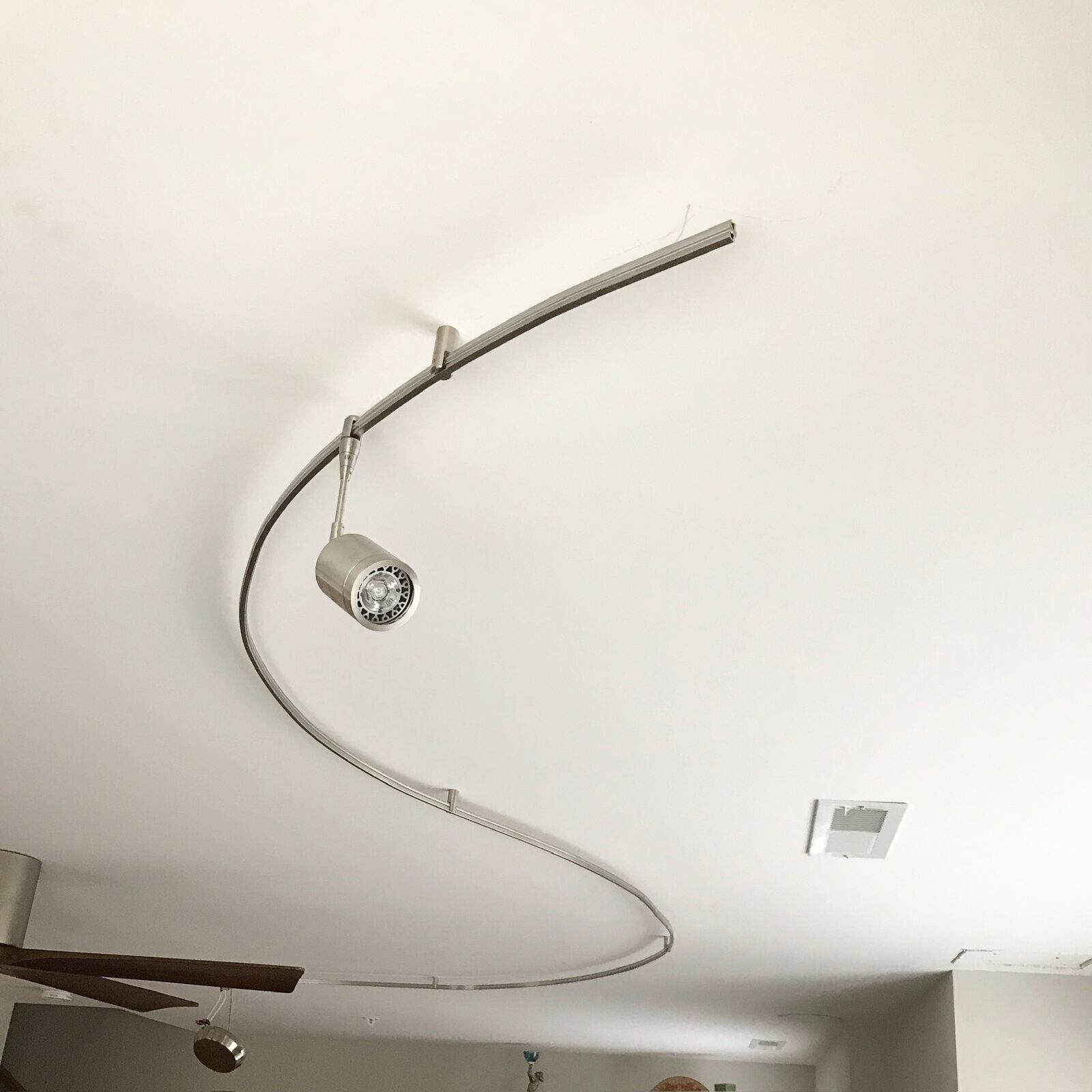 Curved track lighting installed on a living room ceiling