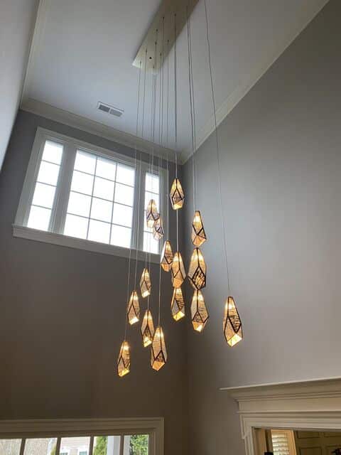 Geometric pendant cluster hung from a tall foyer ceiling
