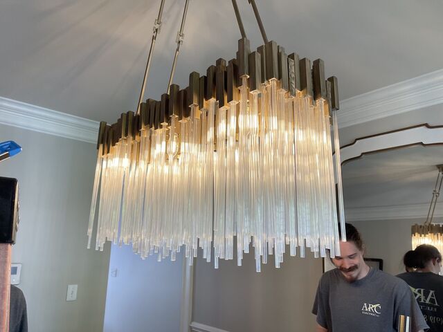 Glass-rod linear chandelier over a dining table