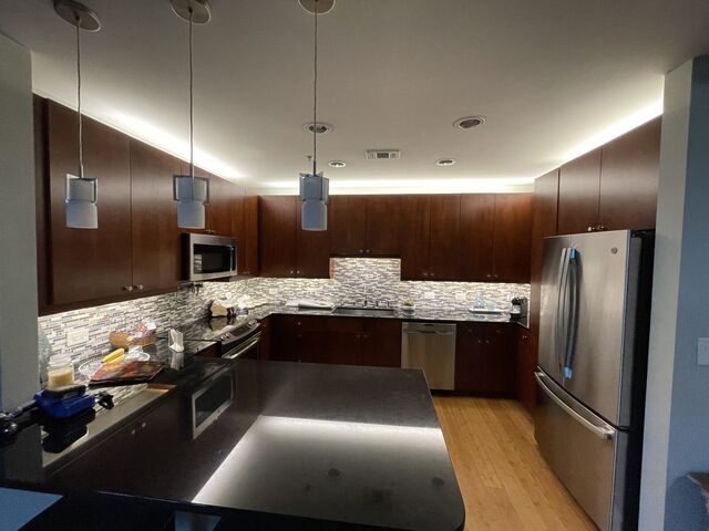Pendants, under-cabinet lighting and cove lighting layered in a kitchen