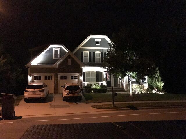 Landscape lighting across the front of a home at night