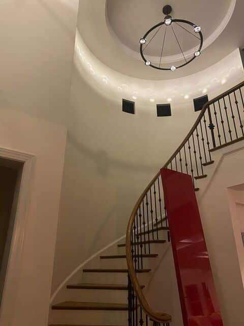 Matching orb chandeliers hung in a curved stairwell