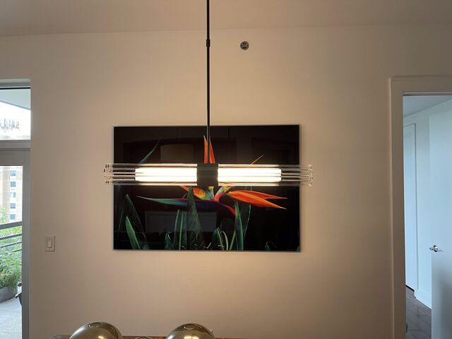 Linear picture light mounted over a painting