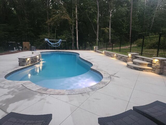 Lights built into the stone wall of a pool, seen in daylight