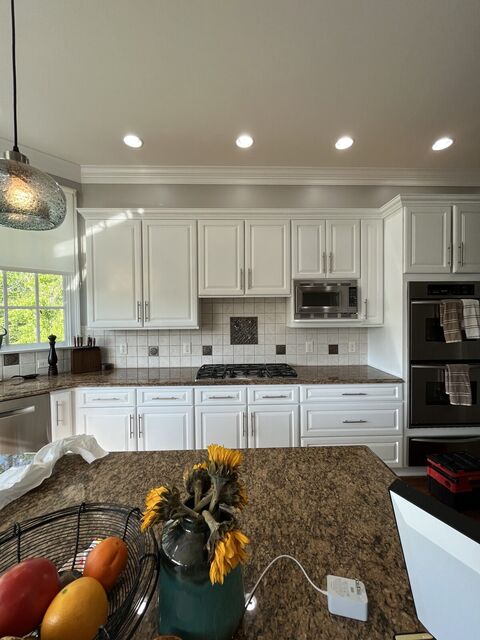 Recessed LED lights and pendants across a kitchen ceiling