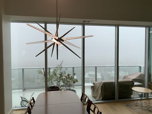 Starburst chandelier in a dining room with a view of the city