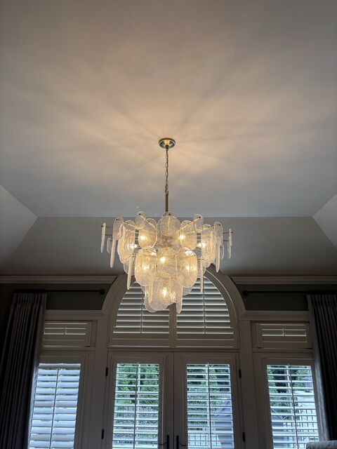 Tiered crystal chandelier in a bedroom with a tray ceiling
