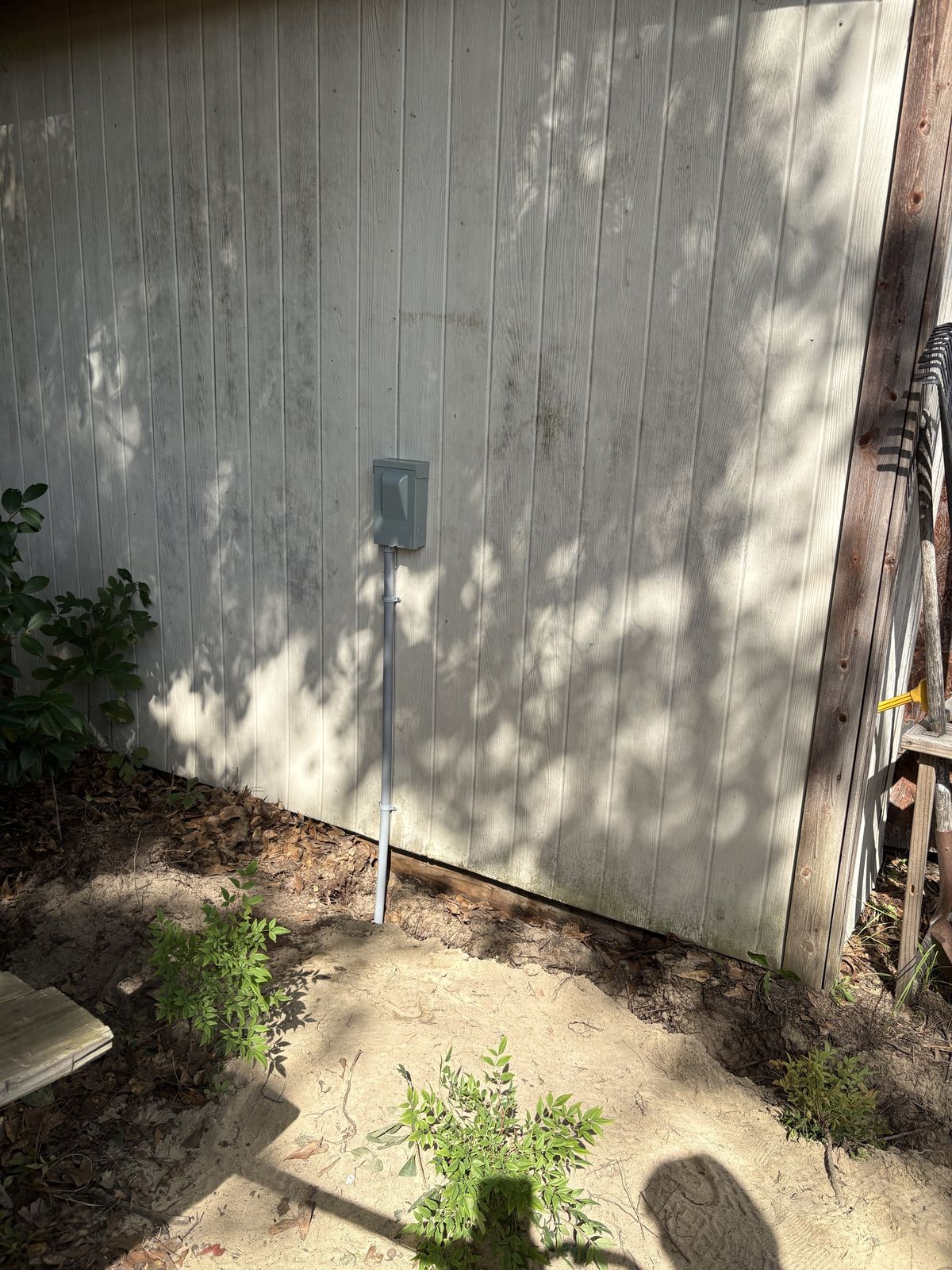 Finished outdoor disconnect with conduit on the side of a second shed