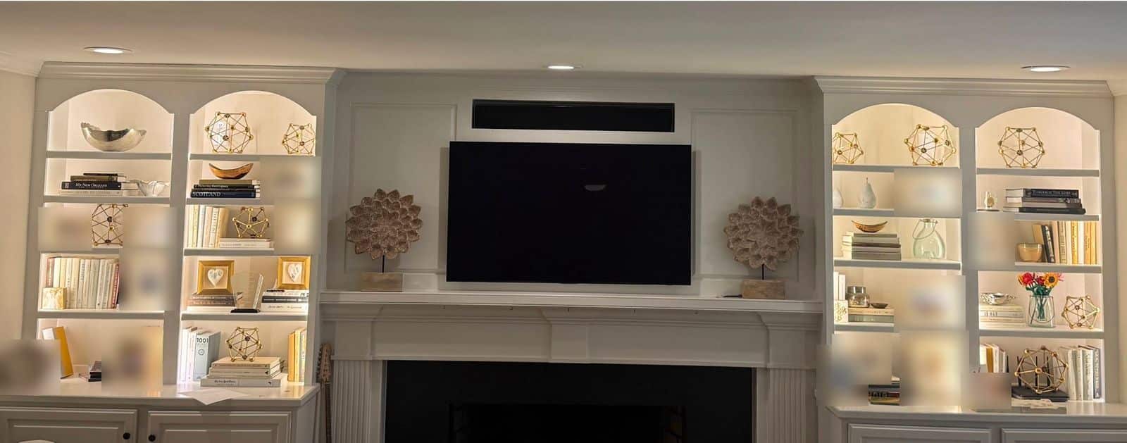 Built-in bookshelves on both sides of a fireplace in Raleigh, NC, evenly lit with new LED lighting