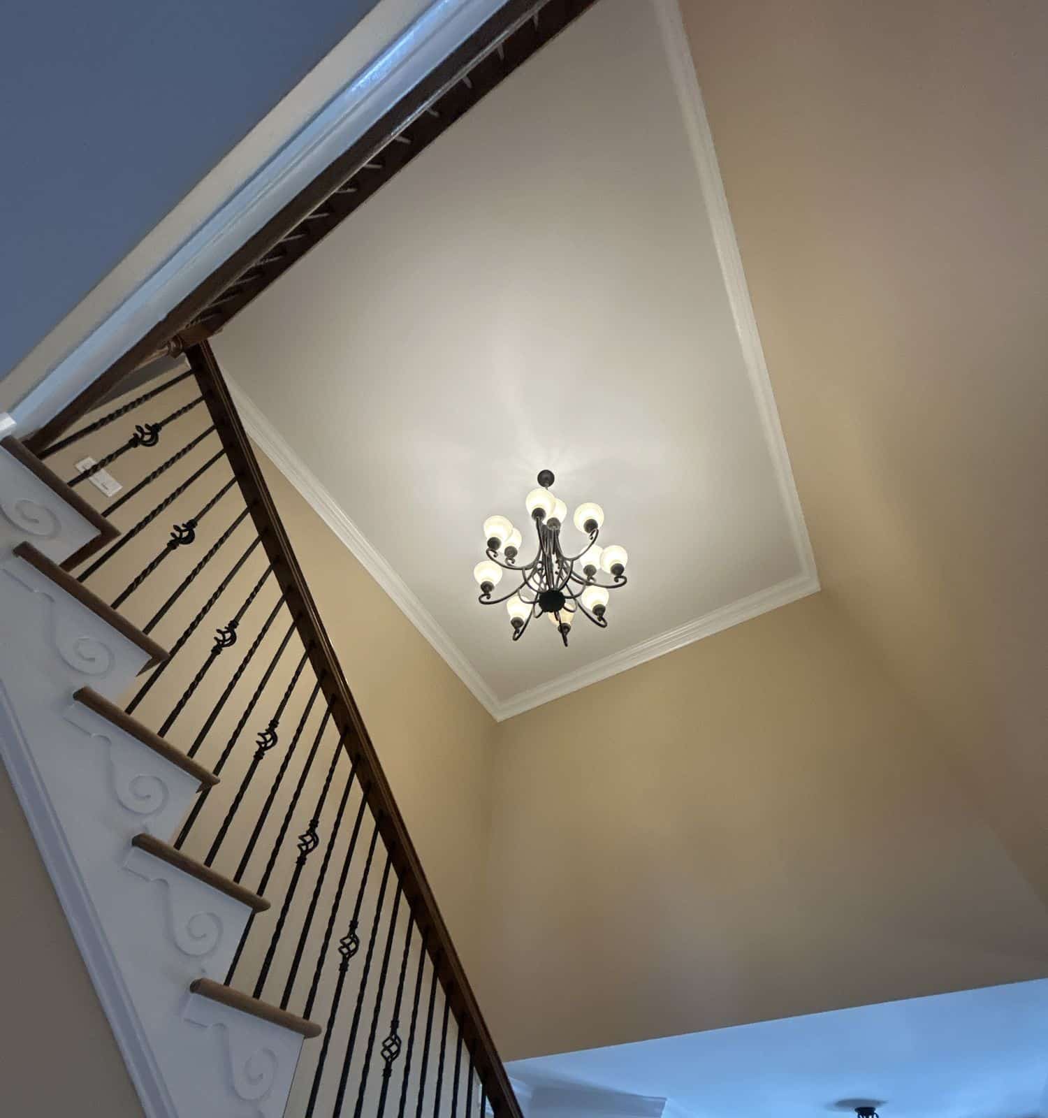 Old bronze chandelier hanging over the staircase in a two-story foyer in Wake Forest, NC